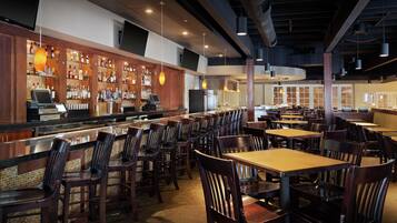A restaurant with a bar area, multiple seating options, and a modern interior design.