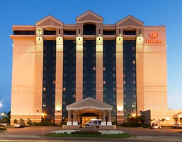 Un hotel grande de varios pisos con una entrada destacada y una fachada bien iluminada.