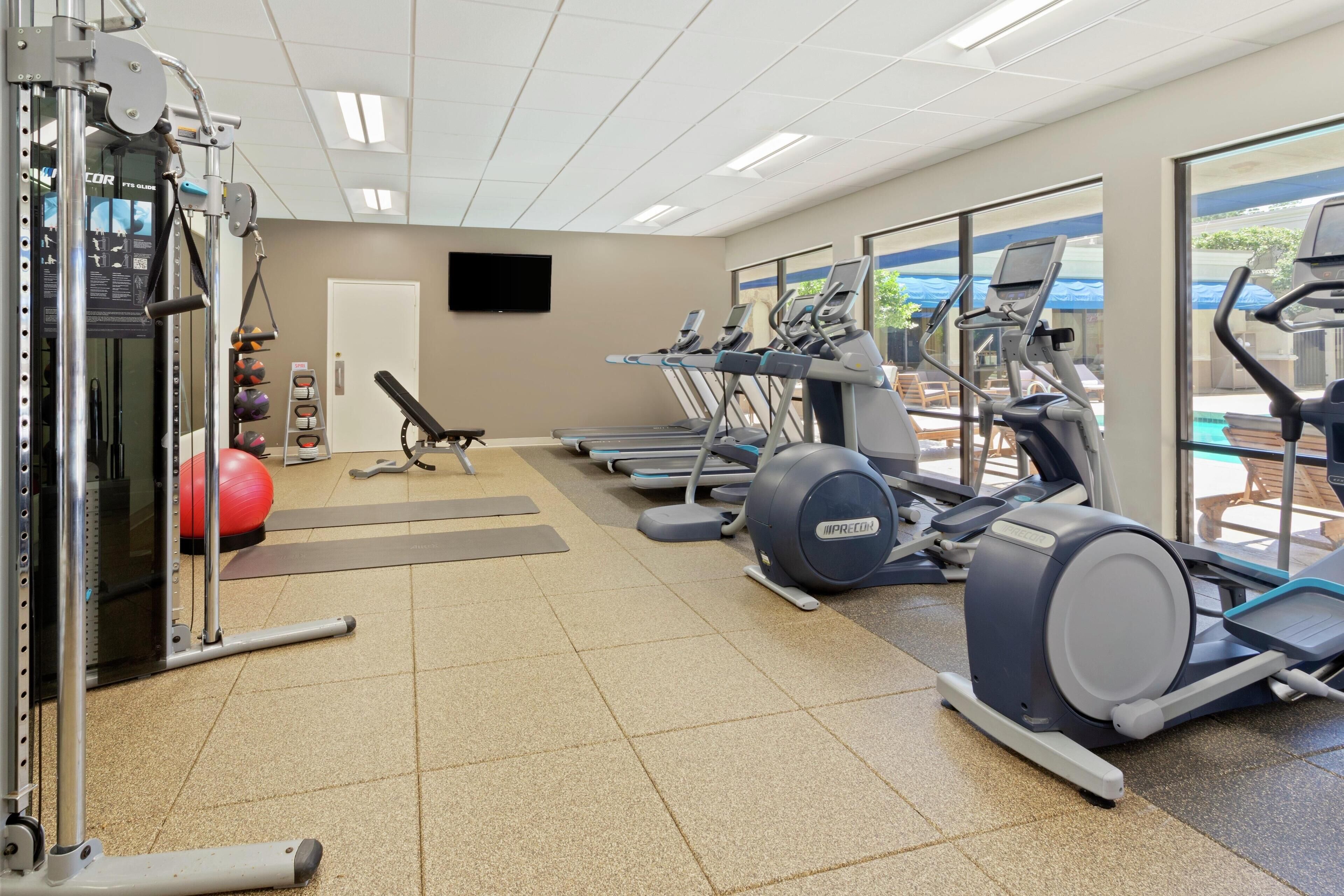 A gym with treadmills, elliptical machines, and free weights.