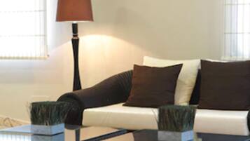 Ein Wohnzimmer mit einer Couch, zwei Beistelltischen und einer Stehlampe.