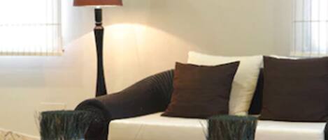 A living room with a sofa, two side tables, and a floor lamp.