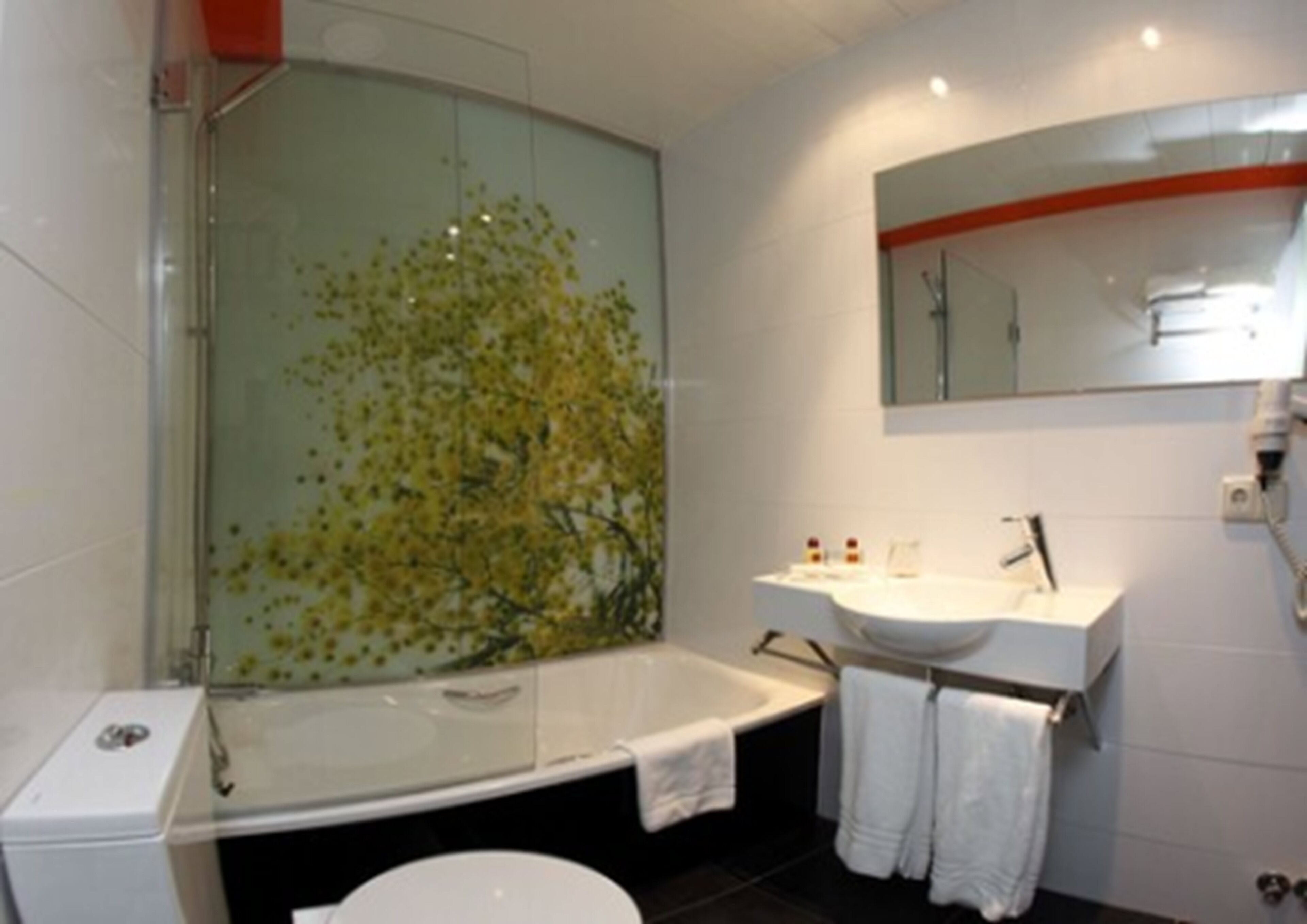 Une salle de bain moderne avec une douche à parois de verre, une baignoire blanche, un lavabo blanc et des toilettes.