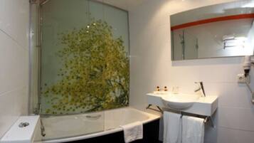 A modern bathroom with a glass shower enclosure, a white bathtub, a white sink, and a toilet.