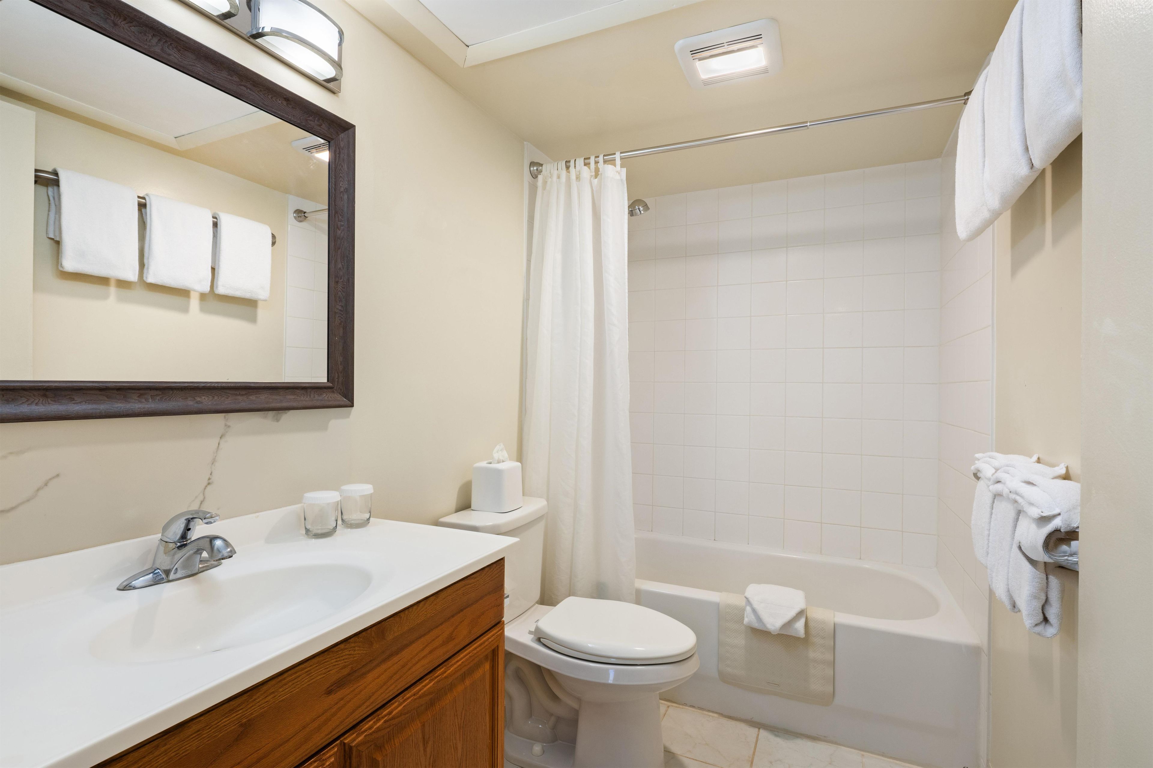Un baño con lavamanos, inodoro y bañera.