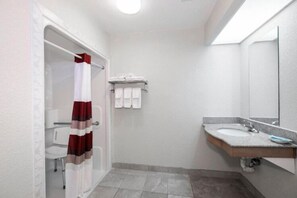 A bathroom with a shower, a sink, and a mirror. - Sonesta Essential Ames (Ames)