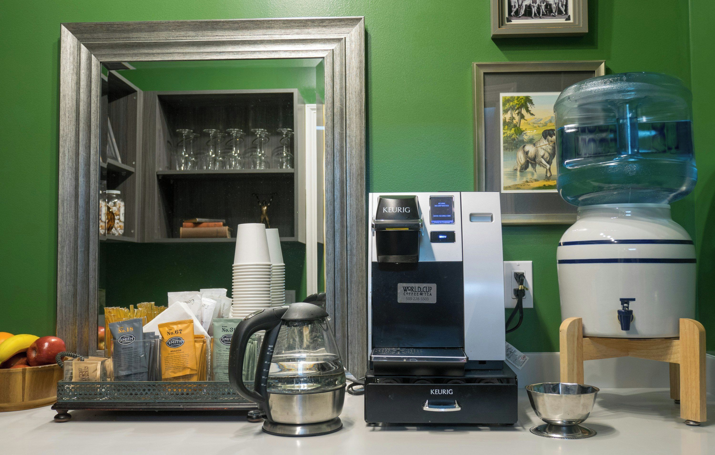 Angolo caffè con macchina Keurig, dispenser di acqua e macinino per caffè.