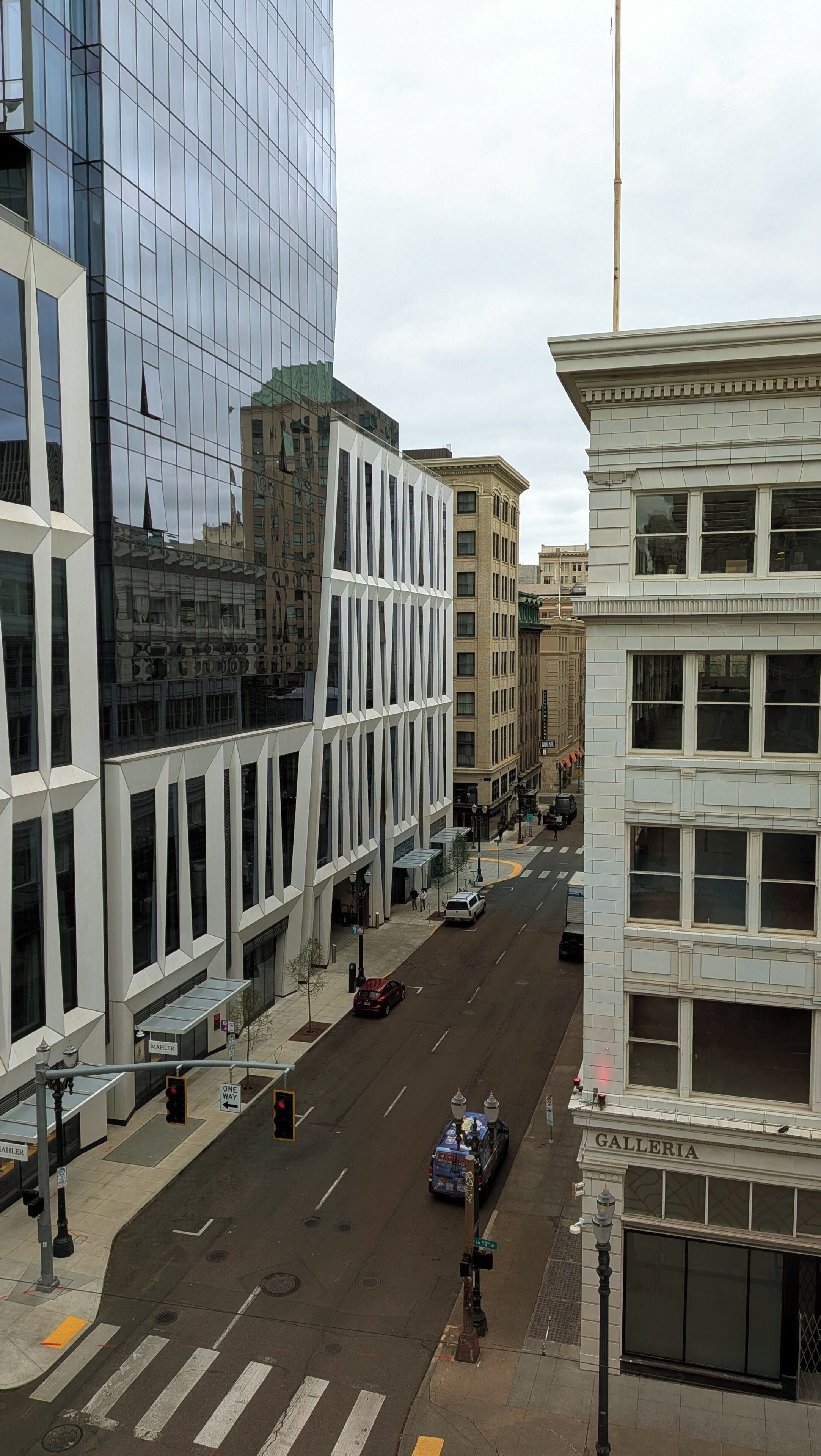A street view with modern buildings, a crosswalk, and traffic lights.