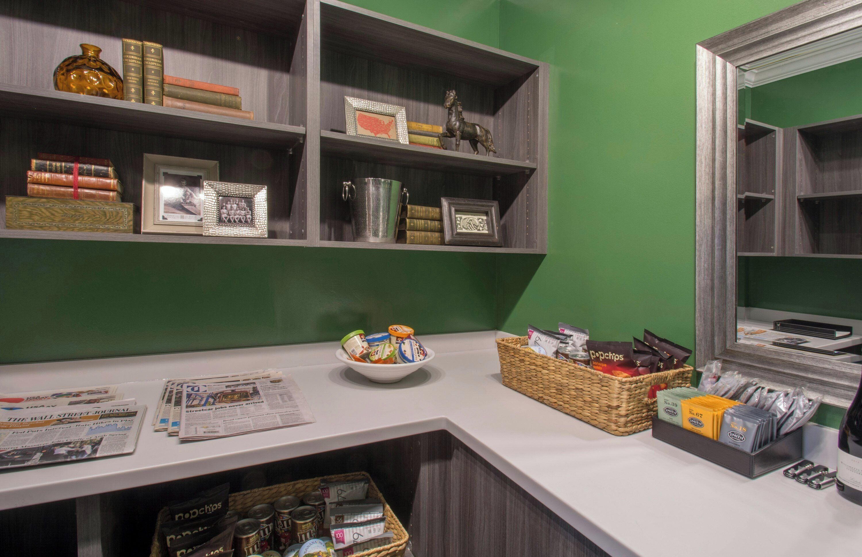 A reception desk with a newspaper, a bowl of snacks, and a wicker basket.