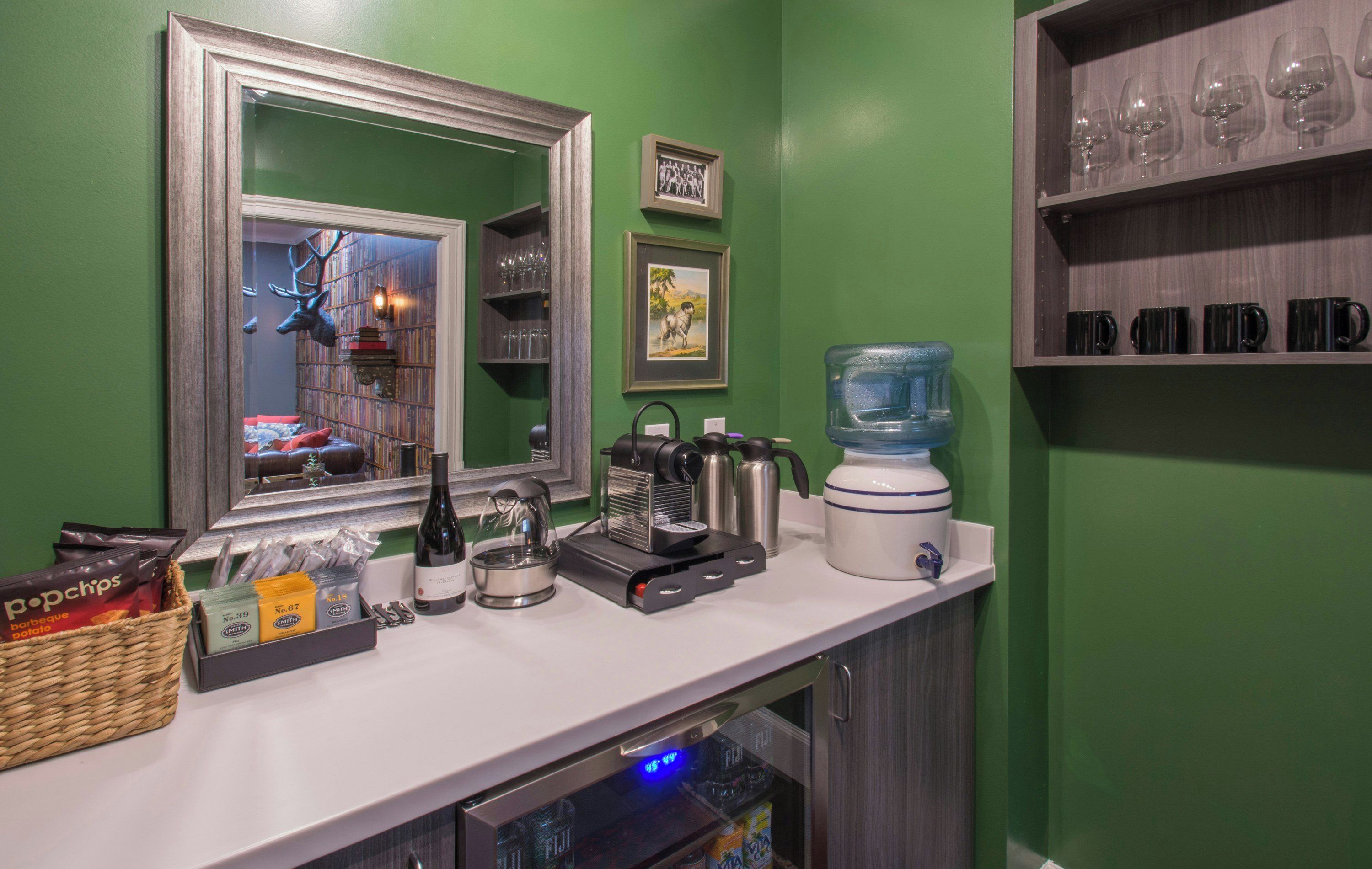 Une petite cuisine équipée d’une machine à café, d’une bouilloire, d’un mixeur et d’un distributeur d’eau.