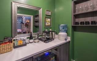 Una kitchenette equipada con cafetera, hervidor, licuadora y dispensador de agua.