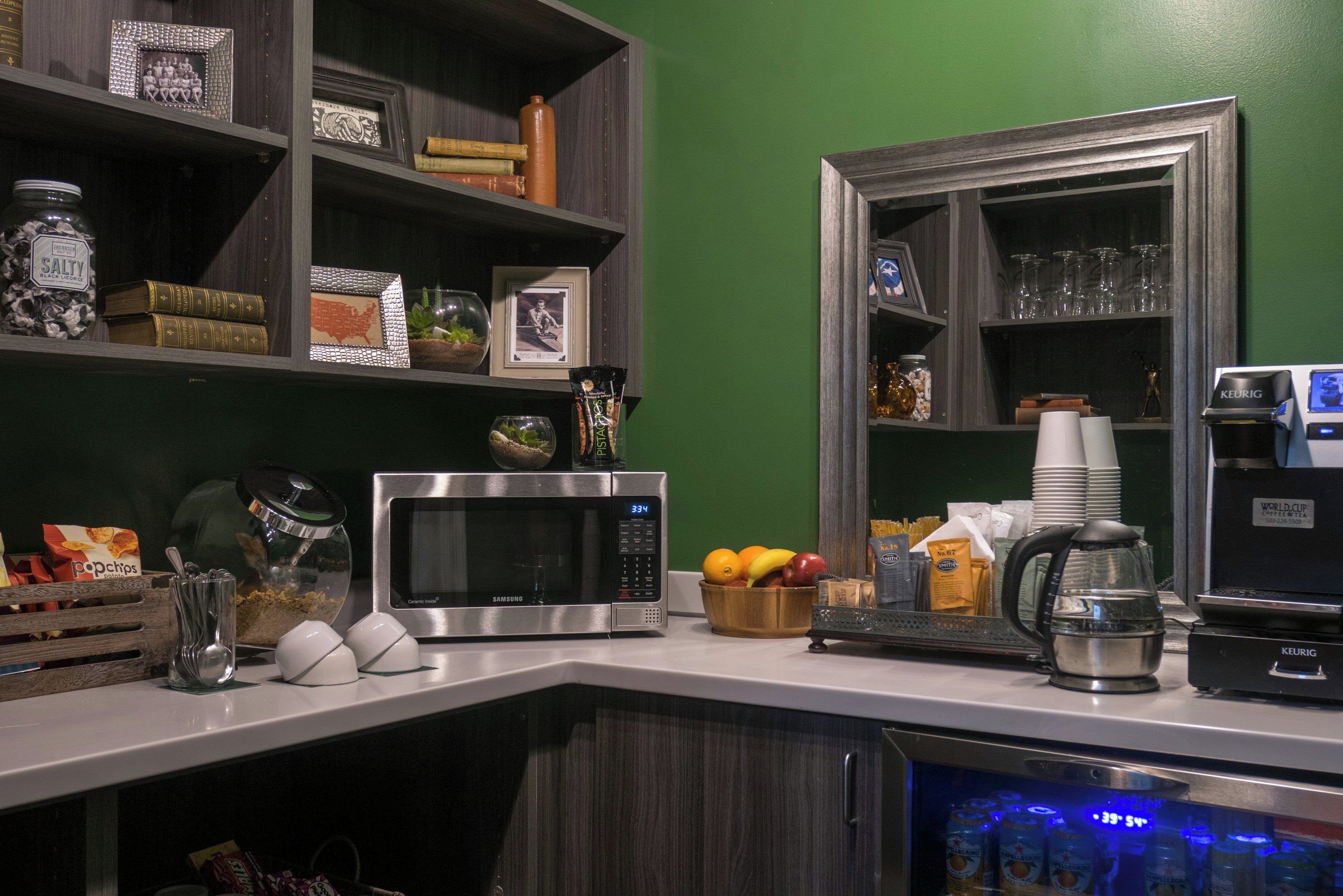 Une cuisine équipée d’un four à micro-ondes, d’une machine à café et d’un panier à fruits.