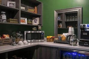 A kitchen with a microwave, coffee maker, and a fruit bowl. - Sentinel Hotel (Portland)