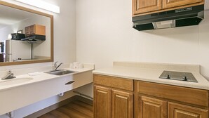 A modern bathroom with a white sink, wooden cabinets, and a mirror. - Red Roof Inn Forsyth (Forsyth)