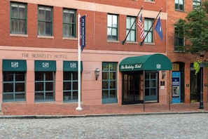 The Berkeley Hotel with a brick facade, multiple windows, and a green awning.