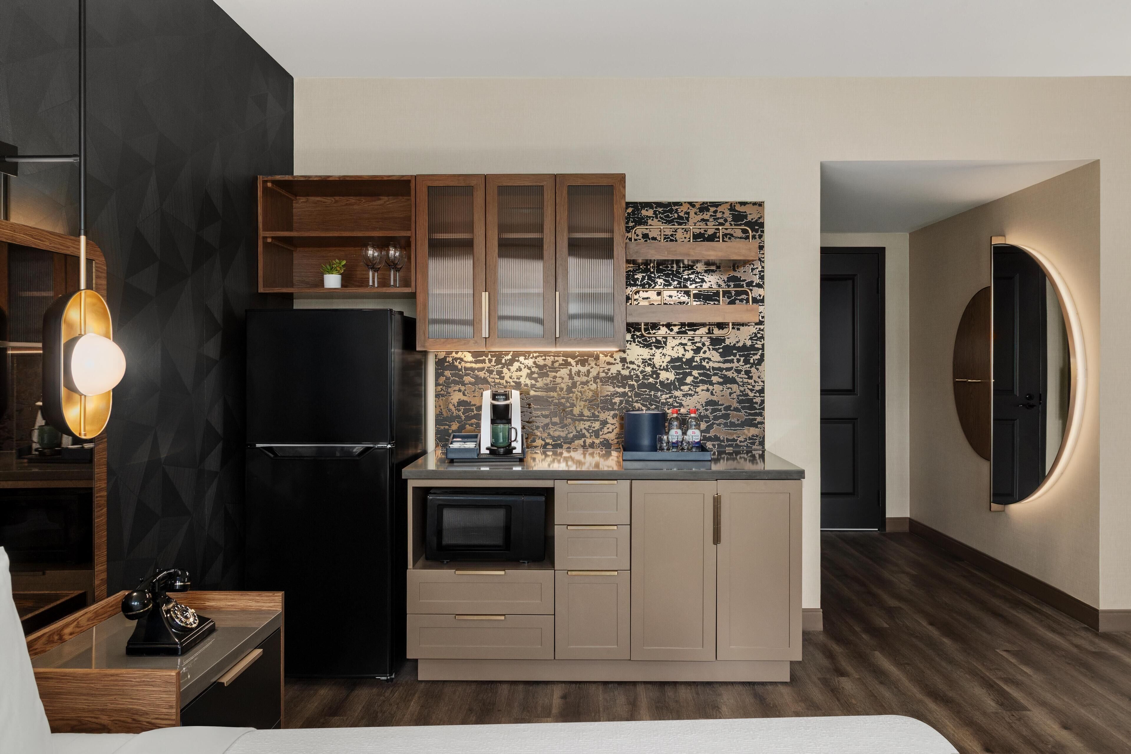 Una cocina moderna con horno empotrado, cafetera y armarios de madera.