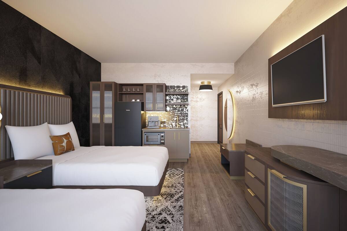 Una habitación de hotel moderna con dos camas, una kitchenette, un televisor grande y un diseño de pared original.