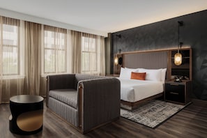 A modern hotel room with a large bed, a seating area, and a nightstand with a telephone. - The Berkeley Richmond, Outset Collection by Hilton (Richmond)