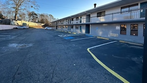 A multi-story motel with a parking lot, a bicycle lane, and a wheelchair-accessible entrance. - Rodeway Inn Jonesboro - Atlanta South (Forest Park)