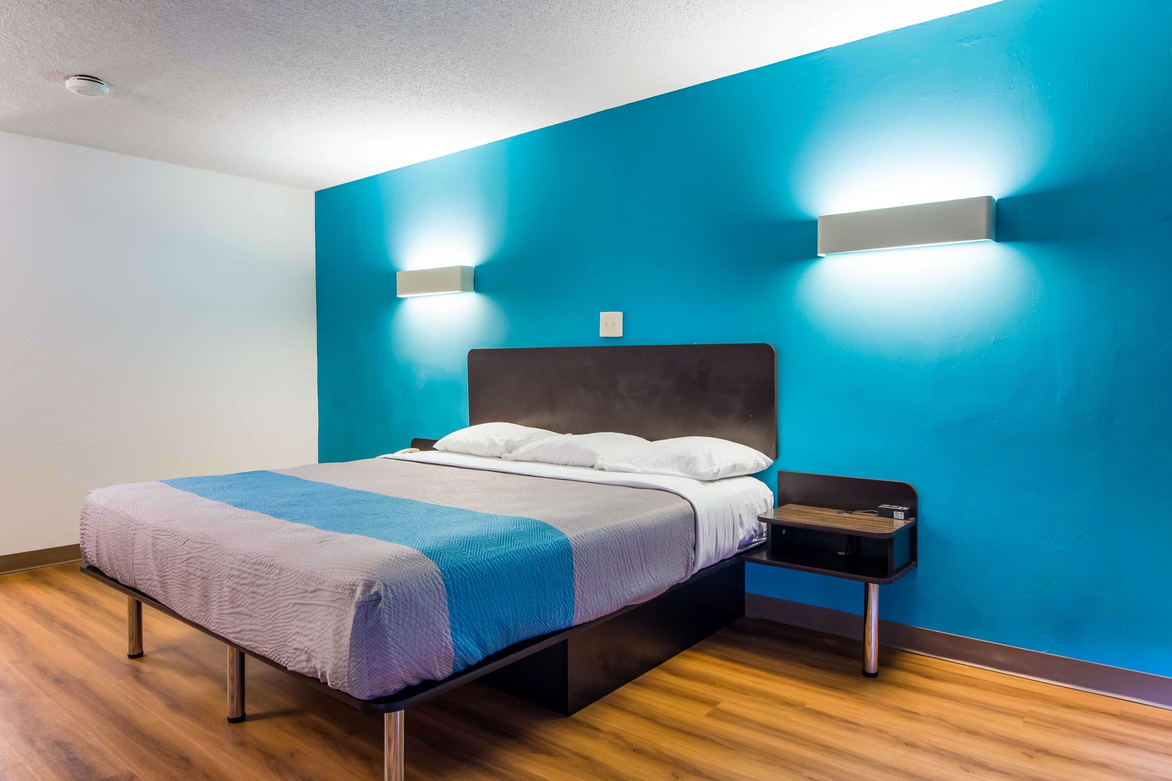 A modern bedroom with a bed, nightstands, and built-in lighting.