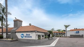 Un hôtel Best Western doté d’un toit recouvert de tuiles, d’une enseigne et d’un parking.