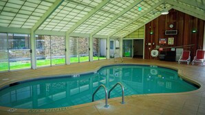 An indoor swimming pool with a tiled floor, a no diving sign, and a wooden wall with a clock. - Holiday Inn Portsmouth by IHG (Portsmouth)