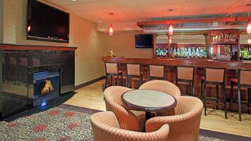 A bar area with a fireplace, bar counter, and seating.