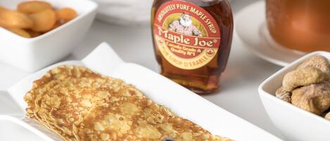 A breakfast setting with a crepe, maple syrup, and a bottle labeled "Maple Joe."