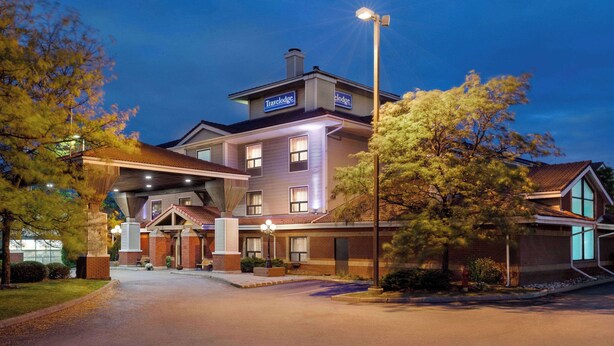 Un hotel grande de varios pisos con una entrada destacada y fachada bien iluminada.