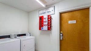 Uma lavanderia automática com uma placa indicando que funciona 24 horas.