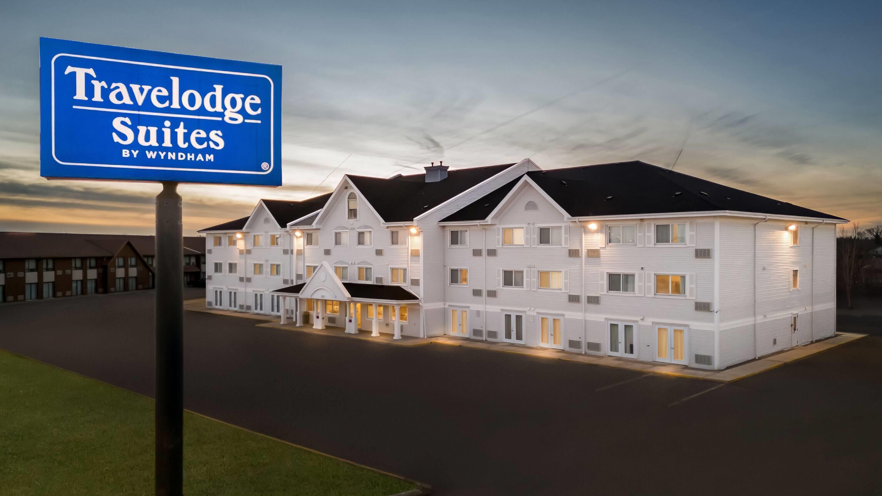 Edificio Travelodge Suites con varios pisos y una entrada cubierta.