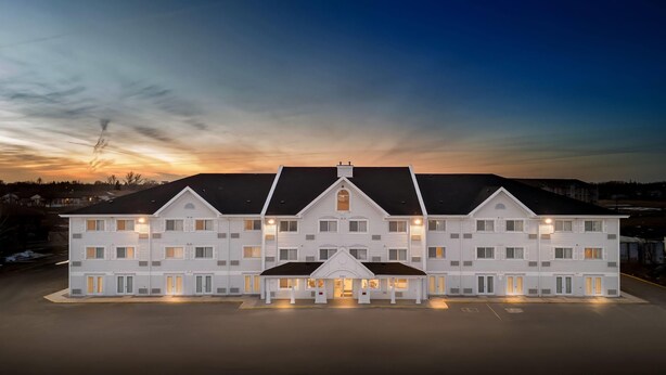 A large, multi-story building with a symmetrical facade, multiple windows, and a central entrance. - Travelodge Suites by Wyndham Regina / Eastgate Bay (Regina)