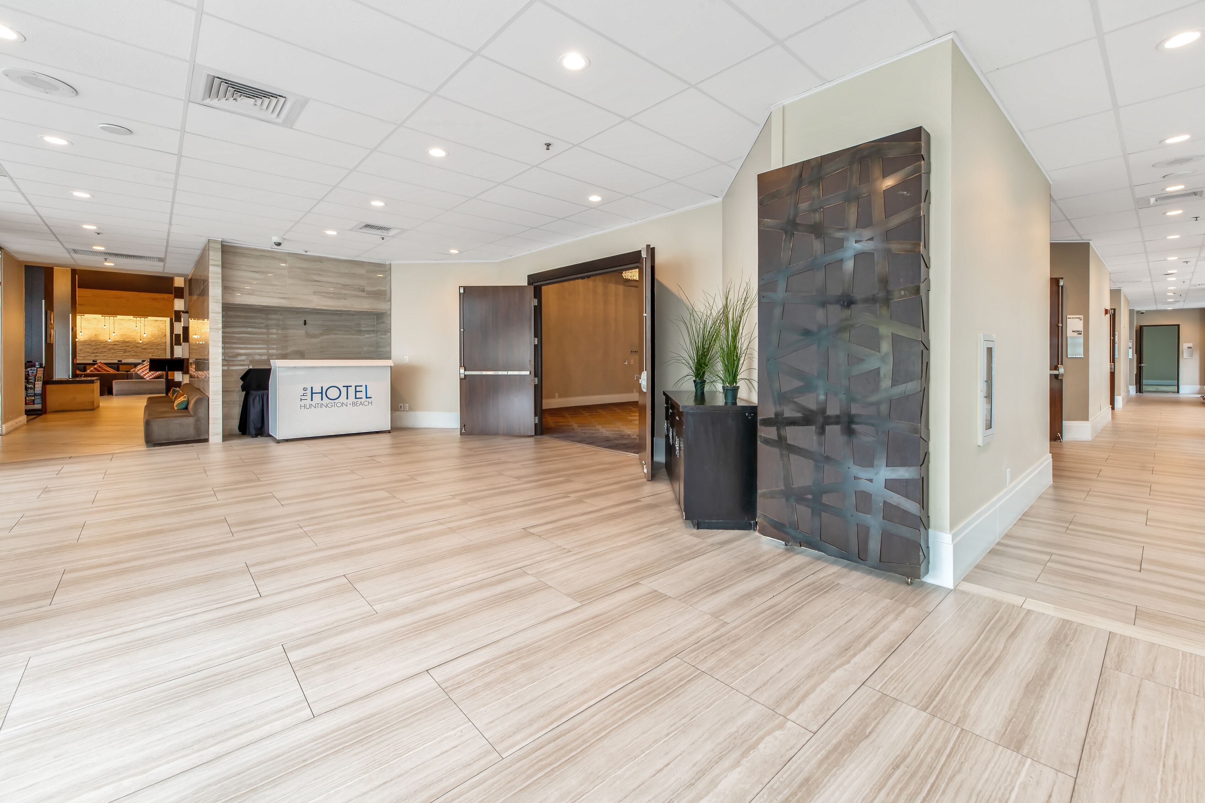 A hotel lobby with a reception desk, a seating area, and a modern interior design.