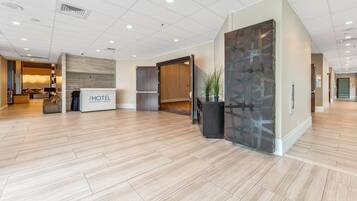A hotel lobby with a reception desk, a seating area, and a modern interior design.