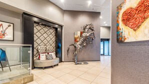 A modern lobby with a tufted headboard, a sculpture of a horse, and a large abstract painting. - Hotel Huntington Beach (Huntington Beach)