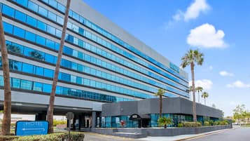 Hotel features a sleek glass facade, flat roof, and horizontal windows.