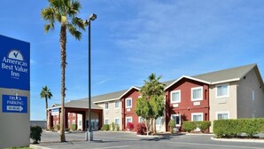 Un hôtel avec une enseigne indiquant « Americas Best Value Inn » et une autre indiquant « Parking pour camions ».
