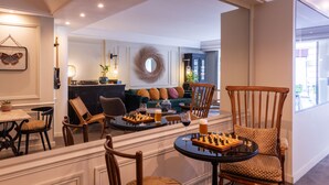 Un amplio salón con chimenea, asientos cómodos y un tablero de ajedrez en una mesa.