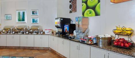 A breakfast bar with various food items and a coffee machine.