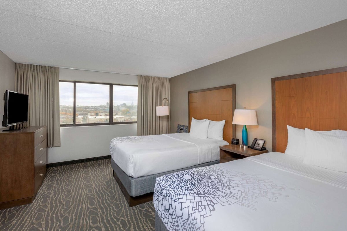Escritorio, cortinas blackout y tabla de planchar con plancha