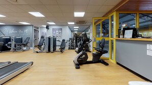 A gym with various exercise equipment, a reception desk, and a sign indicating a members area. - Holiday Inn Runcorn by IHG (Runcorn)