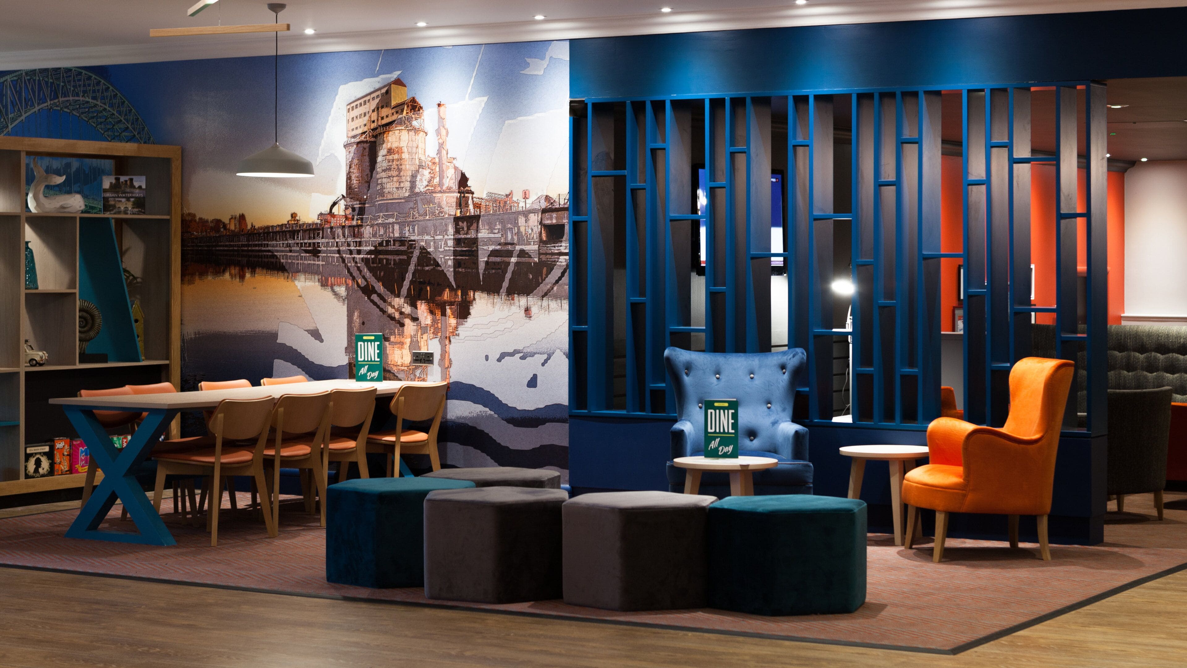 A modern interior with a dining area, seating, and a mural.