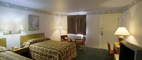 Habitación de hotel con una cama grande, dos mesitas de noche con lámparas, un televisor y un escritorio con una silla.