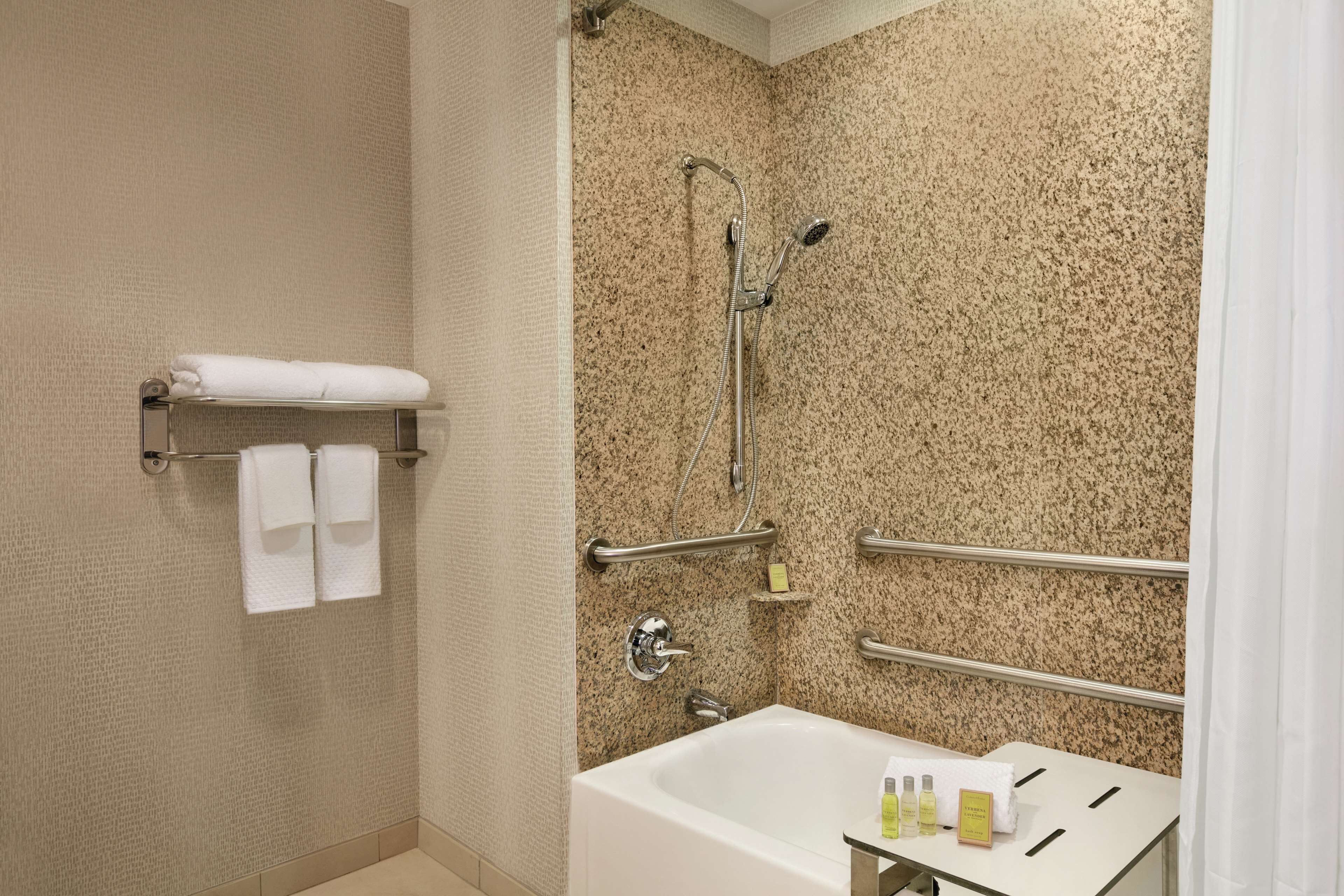 A bathroom with a bathtub, a shower, and a towel rack.