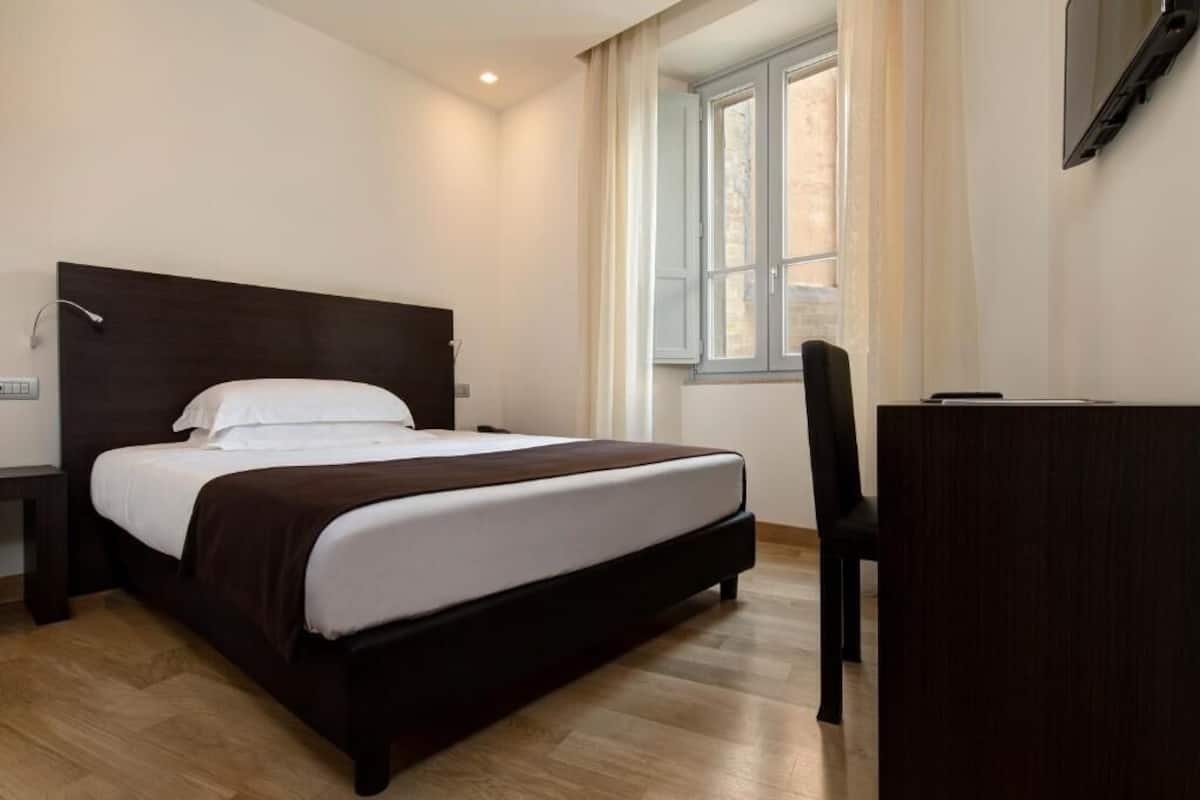 Une chambre à coucher avec un lit, un bureau et une chaise.