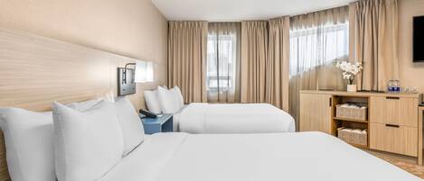 A hotel room with two beds, a desk, a TV, and a wardrobe.