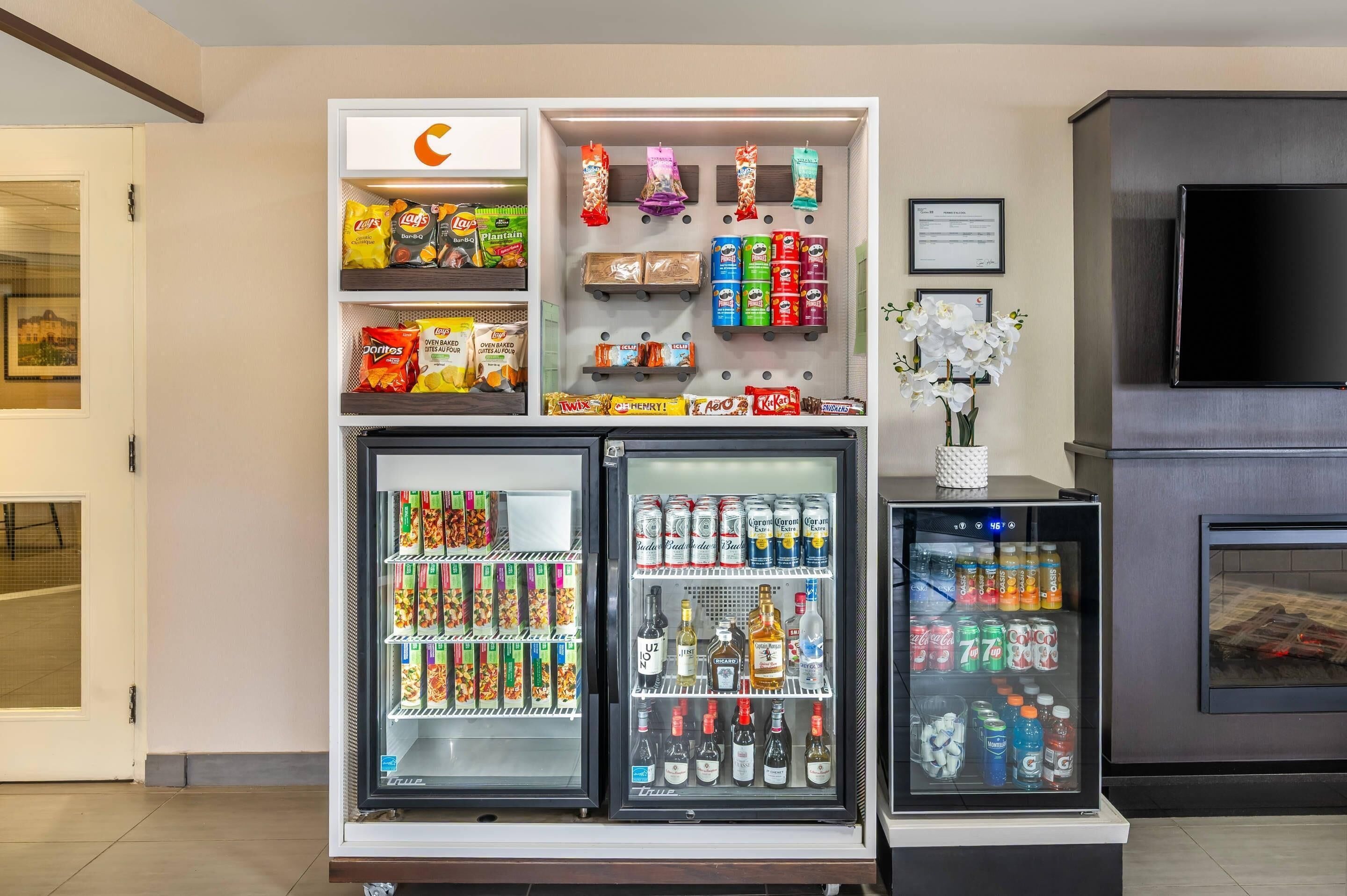 Un distributeur automatique de boissons et d’en-cas en libre-service, proposant diverses marques et types de produits.