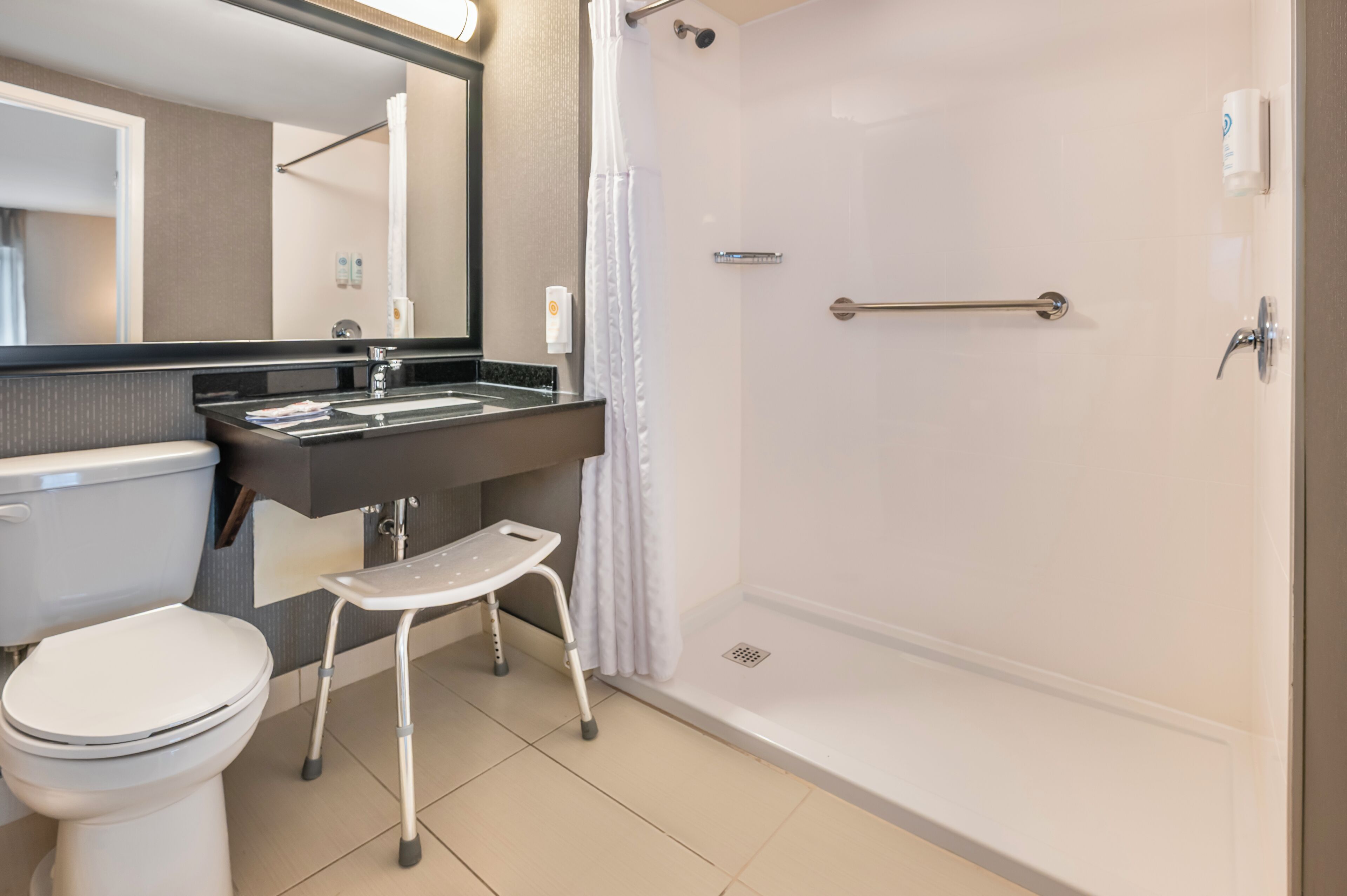 Un baño moderno con inodoro, lavamanos y ducha.