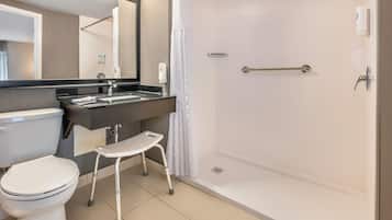 Un baño moderno con inodoro, lavamanos y ducha.