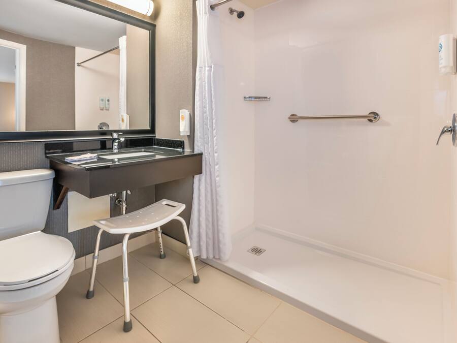 Un baño moderno con inodoro, lavamanos y ducha.