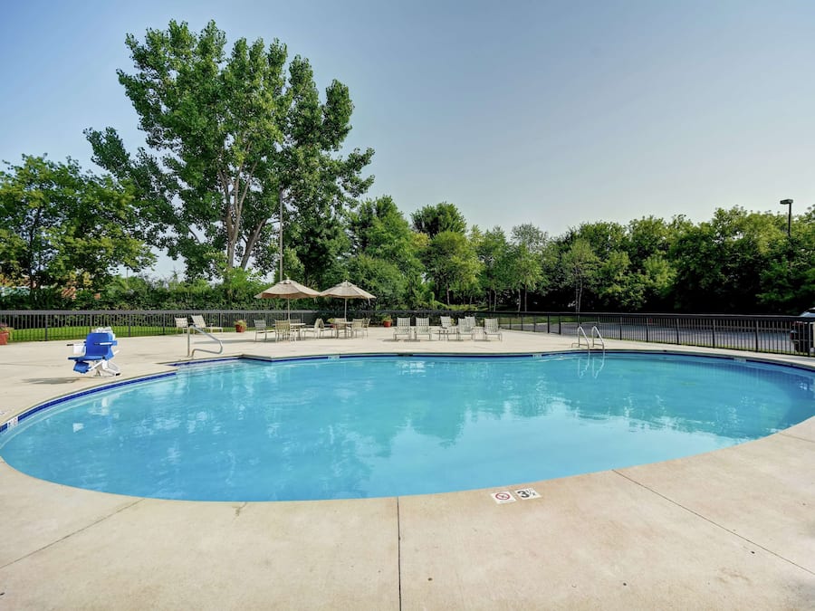 Una piscina al aire libre de temporada, sillones reclinables de piscina